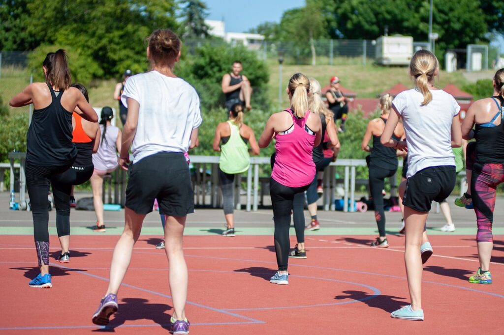Groupe de femmes pratiquant une séance de fitness en plein air pour un mode de vie actif et naturel.