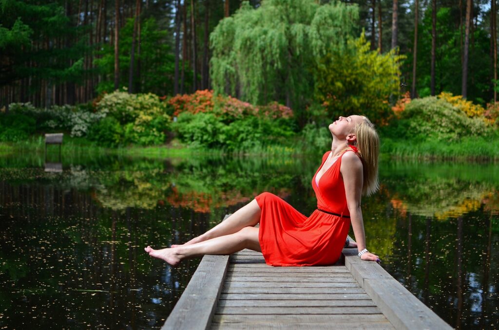 Femme en pleine détente au bord d’un lac, représentant les bienfaits du miel au CBD.