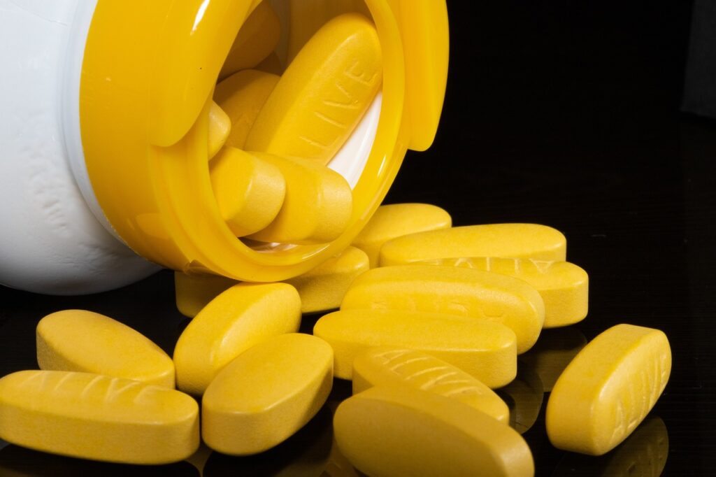 Des pilules jaunes représentant les médicaments traditionnels, souvent associés à des effets secondaires.